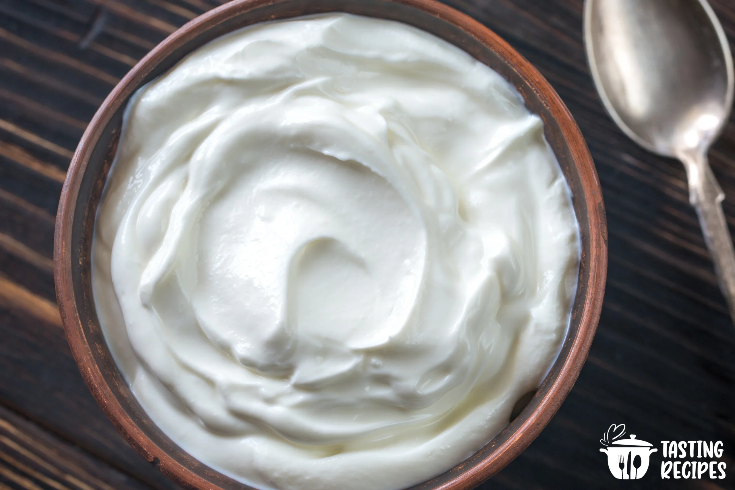 Various Greek yogurt substitutes on a wooden table